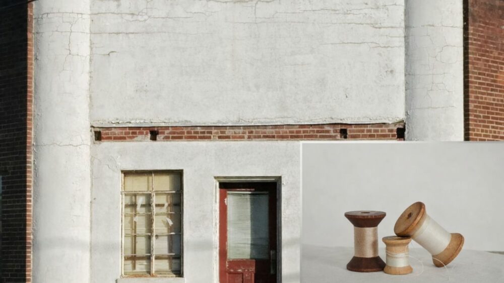 Fasad av gammal byggnad med fönster och dörr, med tre trådrullar i förgrunden.